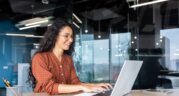 Someone sitting at an office desk using a laptop