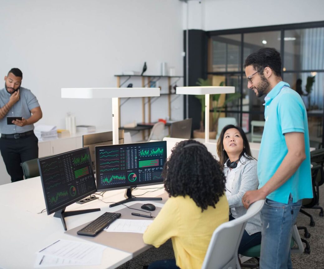 Tech team analysing data on computer screens